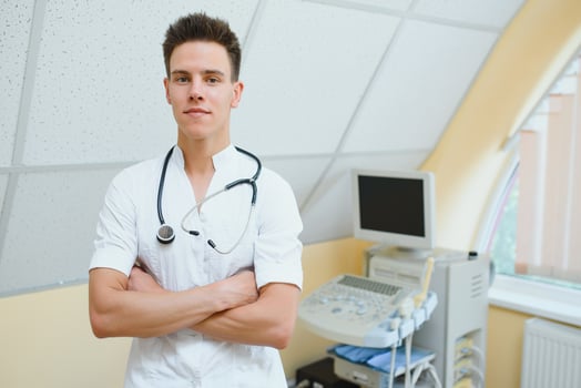 Male doctor in mask with ultrasound equipment in the clinic office photo