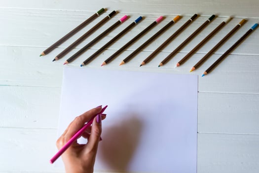 Woman is drawing on a white paper. Tools for drawing, photo