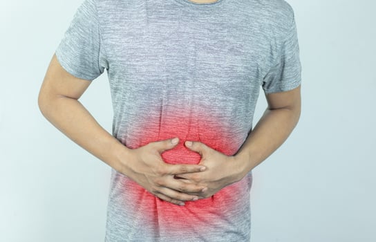 Man suffering with severe stomach pain. Hand of mature guy holding abdomen suffering from ache, diarrhea or indigestion problem. photo