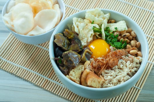 Bubur Daging Spesial or Special Meat Porridge contains white rice with side dishes of grilled beef slices photo
