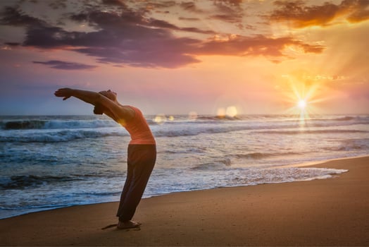 Young sporty fit woman doing yoga Sun salutation Surya Namaskar photo