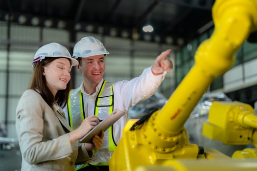 Factory engineers inspecting on machine with smart tablet. Worker works at heavy machine robot arm. The welding machine with a remote system in an industrial factory. Artificial intelligence concept. photo