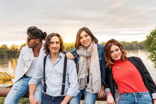 group of best friend have fun in front of a big river in autumn at sunset photo