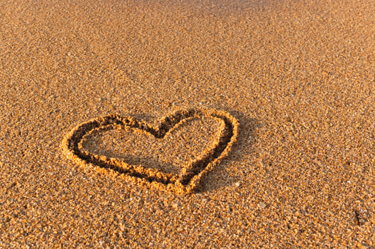 Heart drawn in the sand. Beach background. Top view photo