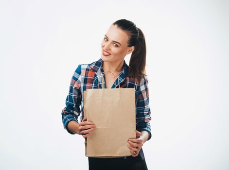 Woman is holding grocery shopping bag on white background. Paper bags in hands. Isolated background. photo