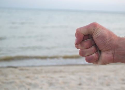 The sand is pouring from male hands. photo