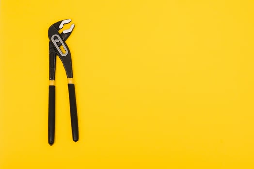Yellow locking pliers isolated on yellow background with clipping path photo