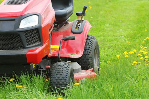 Mowing or cutting the long grass with a lawn mower . Gardening concept background photo