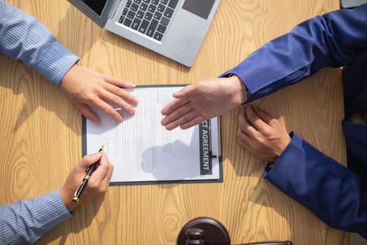 contract was placed on table inside legal counsel's office, ready for investors to sign the contract to hire a team of lawyers to provide legal advice for their investment. legal consulting concept photo