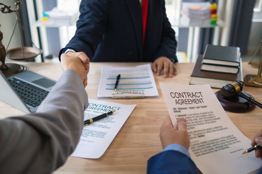 Businessmen and investors discussed joint venture within the legal counsel office and agreed to sign a contract in front of the lawyers within the legal counsel office to witness the joint investment. photo