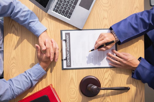 contract was placed on table inside legal counsel's office, ready for investors to sign the contract to hire a team of lawyers to provide legal advice for their investment. legal consulting concept photo