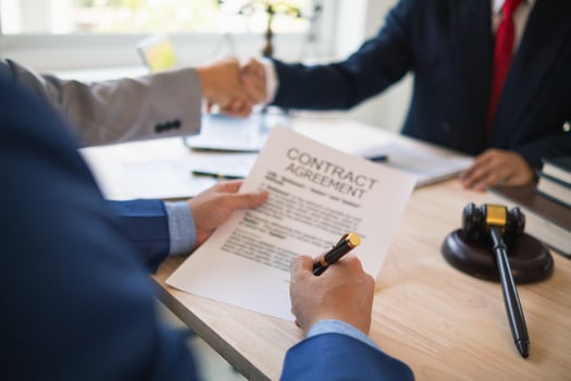 Businessmen and investors discussed joint venture within the legal counsel office and agreed to sign a contract in front of the lawyers within the legal counsel office to witness the joint investment. photo