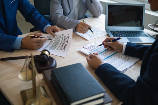 Businessmen and investors discussed joint venture within the legal counsel office and agreed to sign a contract in front of the lawyers within the legal counsel office to witness the joint investment. photo