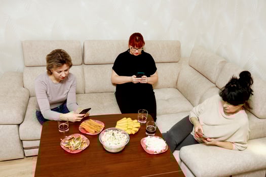 women on the sofa sitting on their phones photo