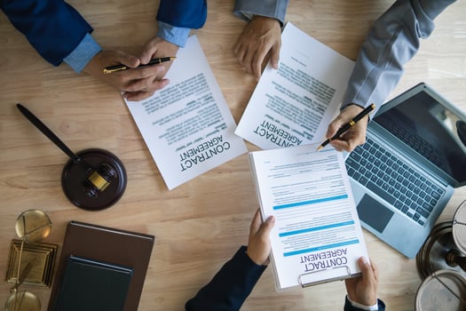 Businessmen and investors discussed joint venture within the legal counsel office and agreed to sign a contract in front of the lawyers within the legal counsel office to witness the joint investment. photo