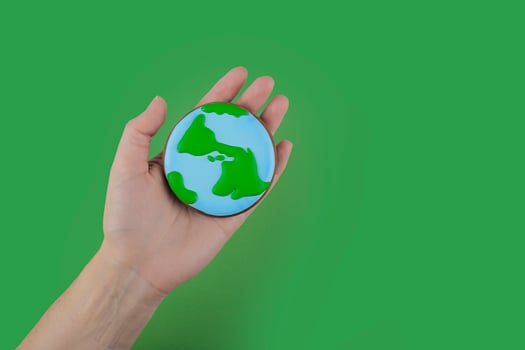 Earth Day concept. Cookie in shape of Earth in hand. photo
