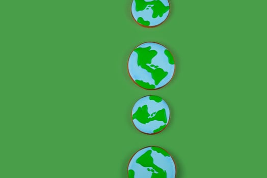 Earth Day concept. Cookies in shape of Earth on green backdrop. Background with copyspace. photo