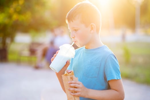 Boy Enjoying Milkshake and Hot Dog photo