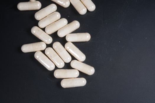 top view of herbal medicine capsule dropping on black background photo