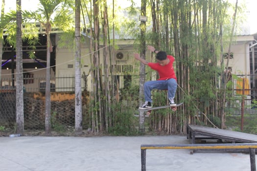 Indonesia - Medan 17 August 2023 an asian man doing skateboard tricks on a ramp photo