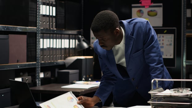 African american male investigator analyzes evidence and conducts a confidential investigation. Black man with expertise in criminology reviews forensic files and classified research information. photo