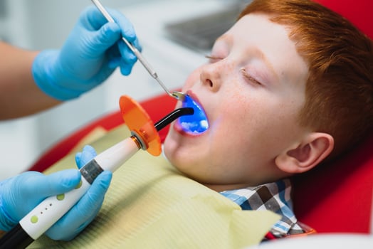 Little boy having his teeth examined by a dentist photo