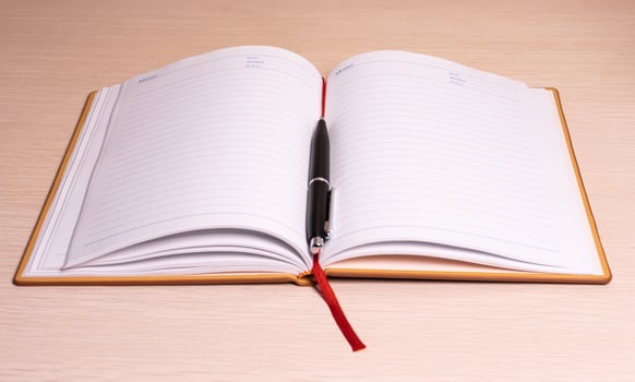 Opened book and pen on a desk. After some edits. photo