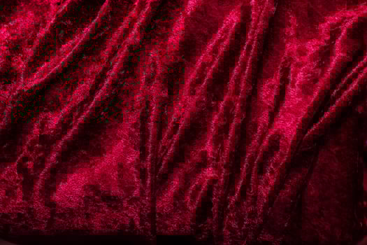 Texture of red velor corduroy fabric with folds photo