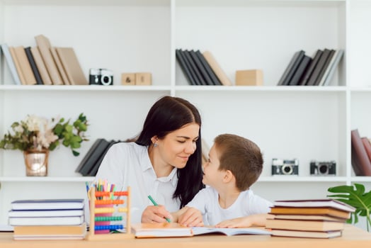 Portrait of pretty tutor and diligent pupil looking at each other while communicating photo