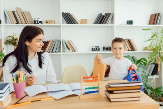 tutor deals with the preschooler with a laptop, a real home interior, the concept of childhood and learning photo