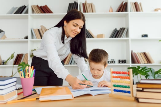 tutor deals with the preschooler with a laptop, a real home interior, the concept of childhood and learning photo