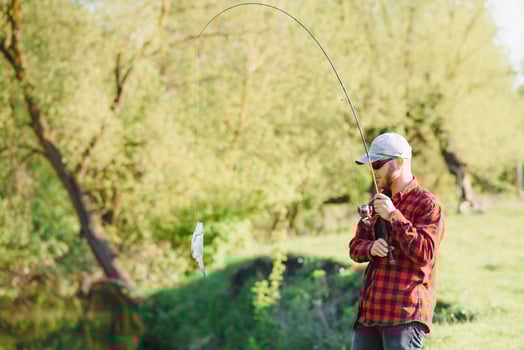 Fisher man fishing with spinning rod on a river bank, spin fishing, prey fishing photo