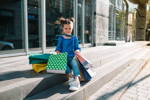 Portrait of beautiful smiling little girl wearing with shopping bag outdoors photo