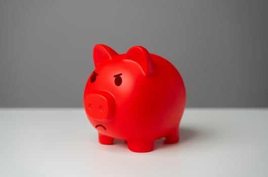 Angry red inflated piggy bank. Inflation is burning savings. Overheated financial market. Difficult economic conditions. Heavy burden on the budget, high expenses and the likelihood of bankruptcy. photo