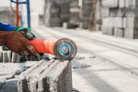man is using a power tool to cut a brick photo