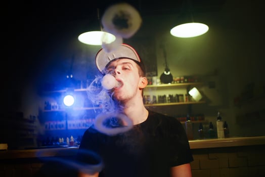The man smoke an electronic cigarette at the vape shop photo
