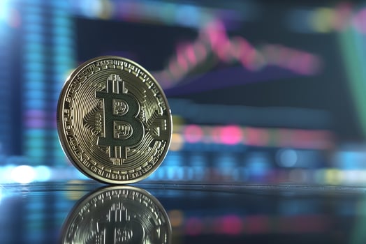 AI generated Bitcoin shiner in front of blurry trading charts screen. photo