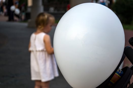 White balloon close-up and children playing in the background. photo