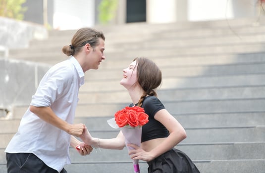 A couple is enjoying a summer vacation in the community area, happily showing their love to each other. photo