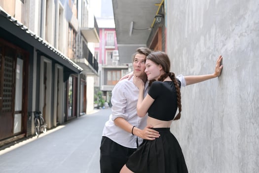 A couple is enjoying a summer vacation in the community streets, happily showing their love to each other. photo