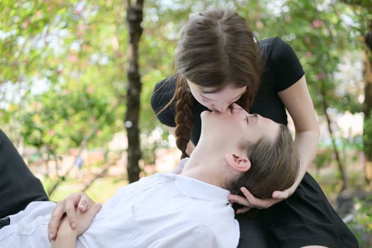 A couple is enjoying a summer vacation in the park, happily showing their love to each other. photo