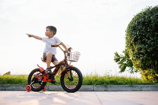 children on a bicycle at asphalt road in early morning. Little boy learns to ride a bike in the park. Happy smiling child, riding a cycling. photo