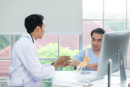 In the hospital office, A medical explains about the foot bones and their treatment to a patient photo