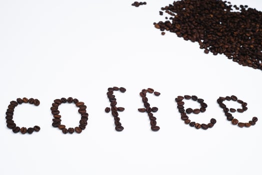Word coffee made from coffee beans isolated on white background photo