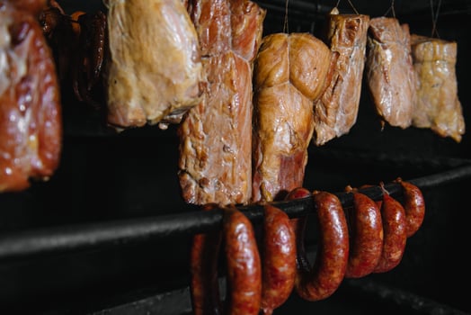 Smoked traditional smoked meat. A composition of smoked cold cuts on a black background. photo