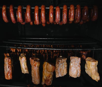Smoked traditional smoked meat. A composition of smoked cold cuts on a black background. photo