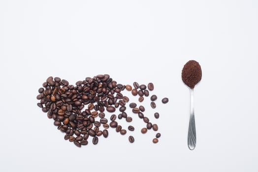 Heart shaped coffee beans with grounds and spoon photo