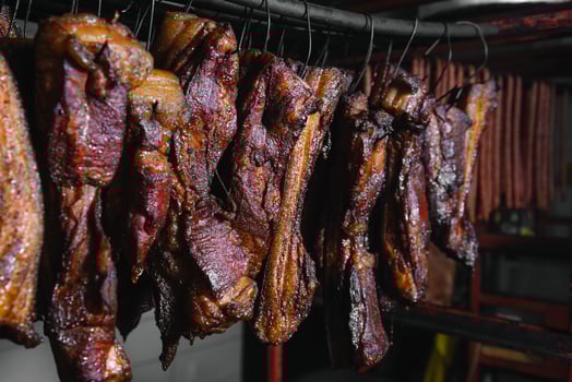 Smoked traditional smoked meat. A composition of smoked cold cuts on a black background. photo