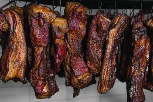 Smoked traditional smoked meat. A composition of smoked cold cuts on a black background. photo