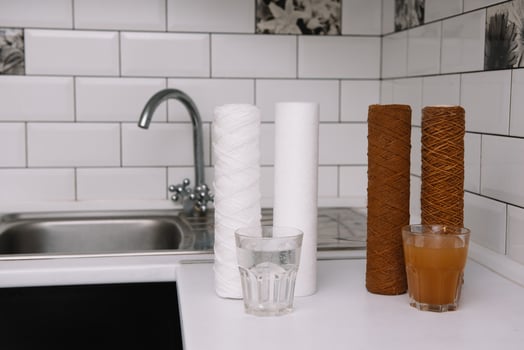 Water filter cartridge used and a glass of rusty water brown coloring and new filter and a glass of clean water. Evidence of contamination of tap water with iron cations. white kitchen photo